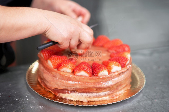 烹饪餐厅糕点师在店厨房制作美味的草莓蛋糕点师制作美味的草莓蛋糕一种图片