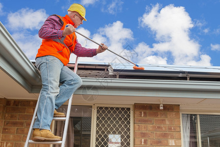 云技术员生态家房屋顶上有经验的工人清洁太阳能电池板图片