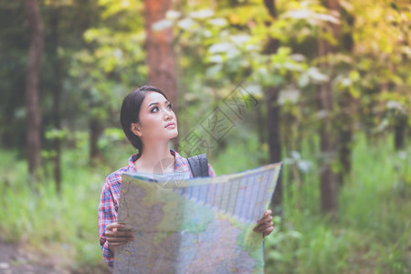 营寻找和放松节假日概念旅行时间的青年妇女探险者在森林中旅行背包步图片