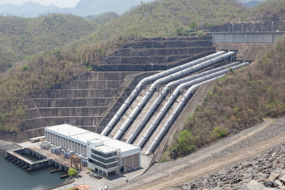 环境电气传送位于大坝下方的水力发电站的图片