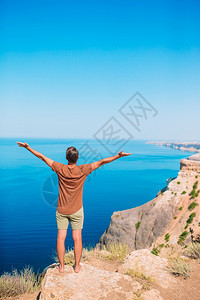 旅行放松在山度假时快乐的户外男人在悬崖海岸边缘旅游者男子克里米亚图片
