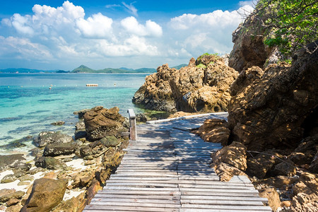 热带岛屿海滩上热带岩石和木桥图片