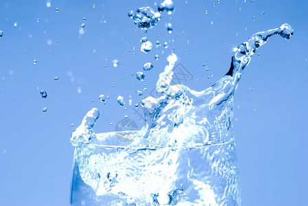 波浪状的冰立方体落到玻璃上洒水的滴喝晶图片