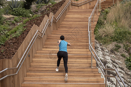 锻炼女人穿着蓝色衬衫跑来去爬上木楼梯人们健康图片