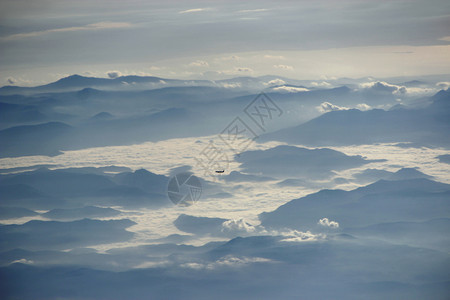 从飞机窗口到另一架飞机过云层和山上风景美观视从飞机窗到另一架越云层和山顶的天空中风景美丽如月平流层户外晚上图片