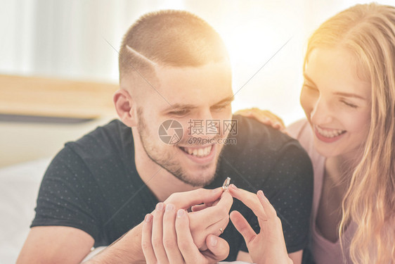 手夫妻在爱情人节的概念中生活在卧室的幸福中夫妻们提议与戒指结为婚伴着白种人天图片