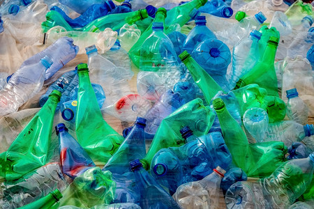 海洋一大堆绿色和蓝塑料瓶子包装在一起紧地把堆垃圾拼凑在起生态浪费图片