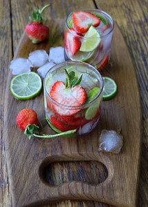 自制绿色苏打冷鲜柠檬水饮料配草莓和石灰特写冷鲜柠檬水饮料配草莓和石灰特写背景图片