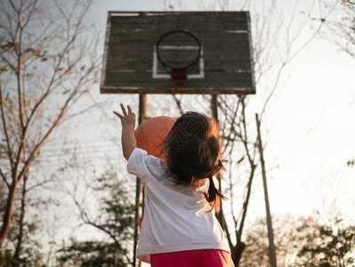 关心在夏日运动场上打篮球的亚洲可爱小孩为幼儿提供健康户外运动活亚洲人女孩图片