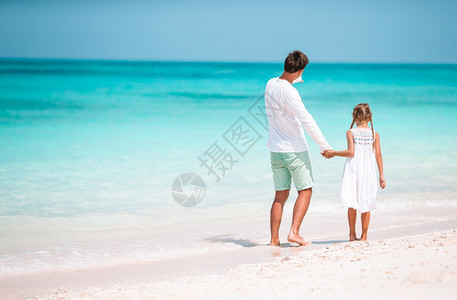父亲和女儿的家庭在海滩度假小女孩和快乐的爸在海滩度假期间玩得开心了小女孩和快乐的父亲夏天趣绿松石图片