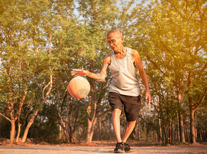 积极的关心花园亚洲年长男子在夏季日运动场打篮球健康生活方式和保健概念康生活方式和保健概念图片