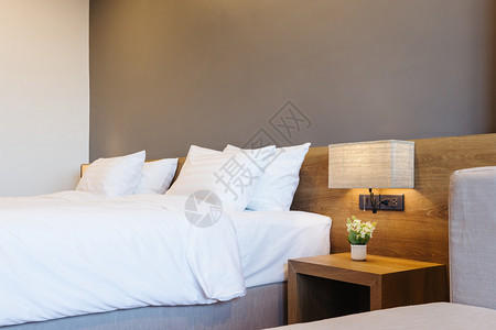 白色的墙室内旅馆卧装饰的白色枕头加灯在床上装饰紧贴白枕头明亮的图片