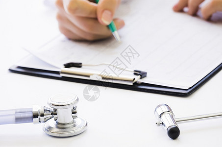 工作临床关心医生手握笔检查医疗报告剪贴板的体检报告图片