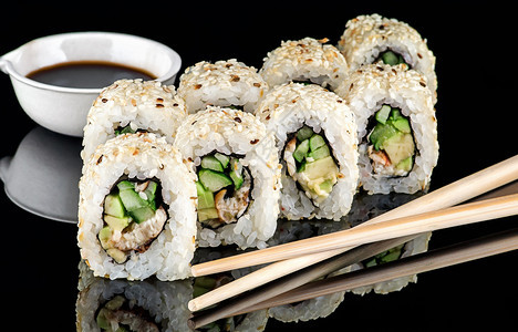 盘子食物紫菜几片寿司卷卡利福尼亚鸡腿和酱油在碗中下一个模糊的背景图片