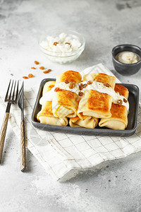 早晨俄罗斯薄煎饼配有干奶酪和葡萄健康传统早餐概念轧制小吃图片
