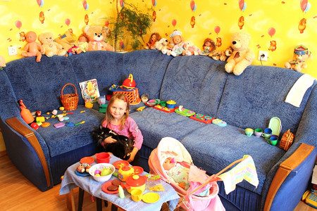小女孩在她房间里玩具和猫咪娃幸福人们图片