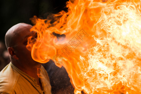 运动骗子火场艺术家在黑暗的干扰中呼吸着火焰轮廓图片