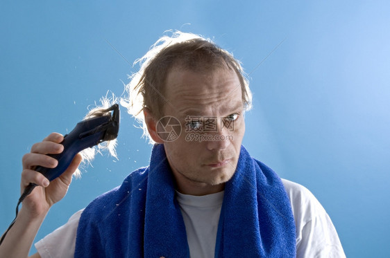 一个穿白色T恤衫的中年男子用剪刀剃自己的头发陈年个人服务图片
