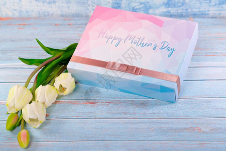 春天卡片明亮的幸福母亲节快乐的一天概念礼物盒和木桌上的花图片