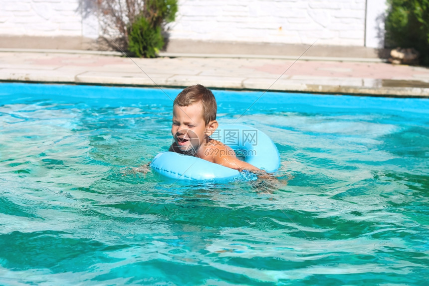 暑假时小男孩在游泳池游泳图片