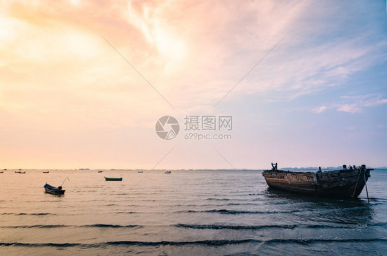 海滩红色的旅行美丽日落天空和海上的捕鱼船图片