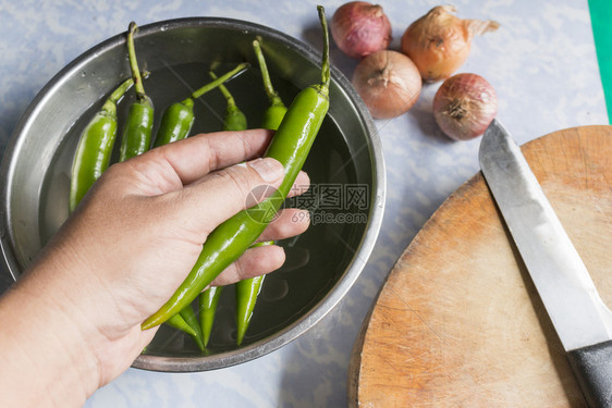 香菜吸引人的厨师用手握着绿辣椒用于厨房切菜食品概念胡椒图片