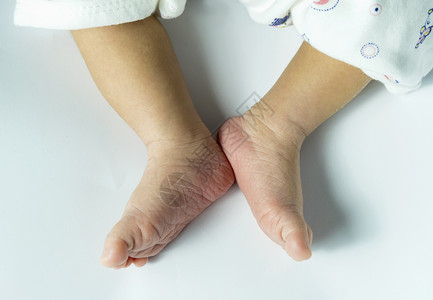 为人父母孩子在白色背景上隔离的婴儿脚近距靠婴儿脚舒适图片
