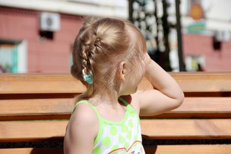在户外长椅上休息的小女孩图片