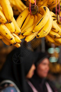 在当地一家杂货店展出些成熟的黄香蕉水果当地一家杂货店展示黑斑点背景模糊的女商贩1586亚洲市场商业图片