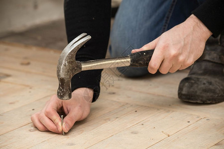 锋利的男用锤子和钉木头翻新概念建设家男用锤子和钉木头翻修概念板银图片