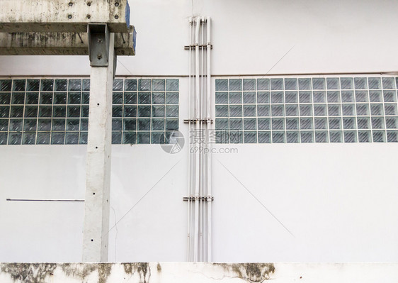 工业的护发素仓库白色混凝土墙上的PVC空调系统管道在工业仓库的白色水泥墙上安装图片