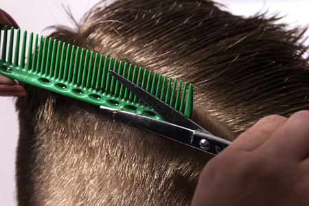 微笑剪刀年轻人从美发店的女理师上剪头在沙龙街的