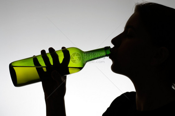 酗酒一个女人用瓶子喝葡萄酒的休眠压力饮者图片