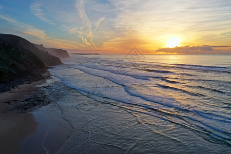 地平线晚上海洋日落时从葡萄牙PraiaValeFigueiras出发图片