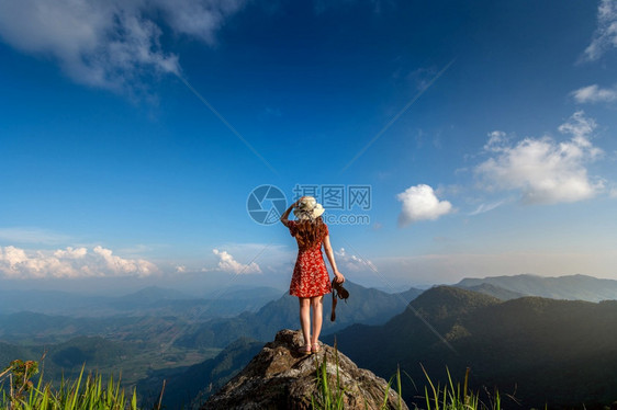 妇女手持照相机站在自然中的岩石顶上旅行概念美丽的站立闲暇图片