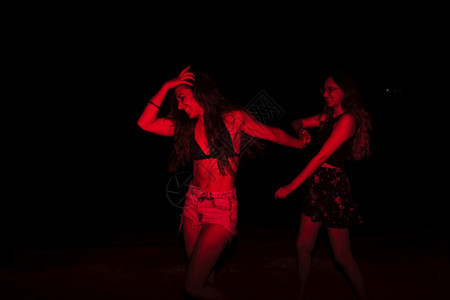 一群在湖边晚宴上玩乐的年轻女晚上带着红灯疯狂女化海滩图片