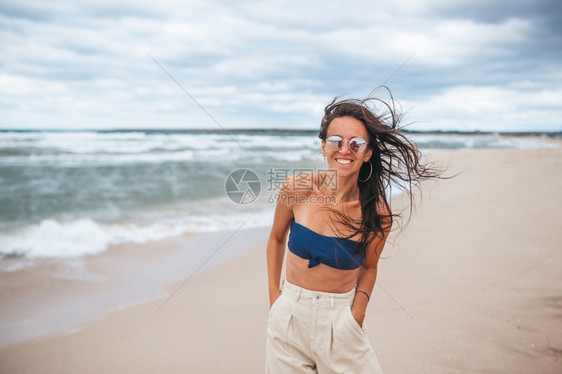 年轻快乐的女子在海滩度假年轻快乐的女子在海滩度假晴天自然蓝色的图片