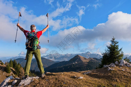 男户外背包客登山者欢呼喜悦的乐快徒步旅行后举起双臂在天空中升起图片