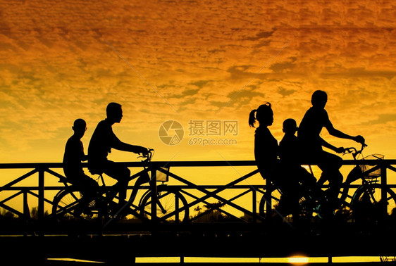 日落时桥上骑车人的剪影图片
