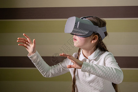 年轻的模拟视觉戴虚现实耳机的女孩通过视频和游戏探索虚拟现实世界未来技术戴虚拟现实耳机的女孩图片