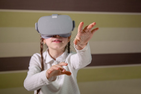 数字的戴虚拟现实耳机的女孩通过视频和游戏探索虚拟现实世界未来技术戴虚拟现实耳机的女孩通过视频和游戏探索虚拟现实世界眼镜工作室图片