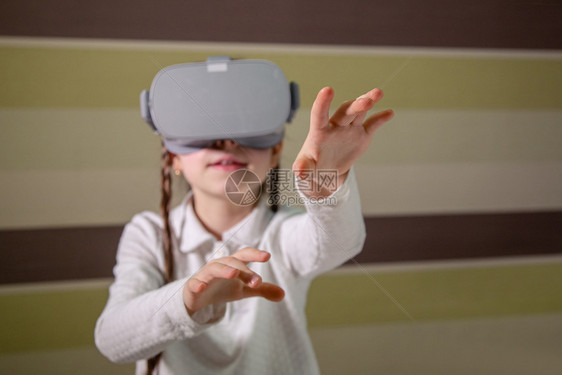 数字的戴虚拟现实耳机的女孩通过视频和游戏探索虚拟现实世界未来技术戴虚拟现实耳机的女孩通过视频和游戏探索虚拟现实世界眼镜工作室图片