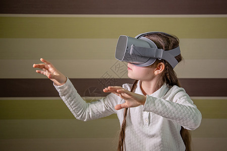可穿戴桌子虚拟现实耳机的女孩通过视频和游戏探索虚拟现实世界未来技术戴虚拟现实耳机的女孩通过视频和游戏探索虚拟现实世界数字的图片