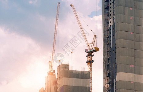 行业Crane在建筑工地上使用雷el提升设备公寓楼建筑工地造起重机对天工程建造起重机与天空对面工作建造起重机商业的工程师图片