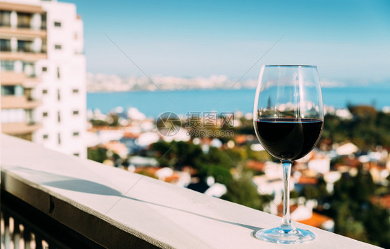 天空浪漫的镇一杯带有红色口标记的酒从阳台上欣赏到一杯带有口红标记的酒图片