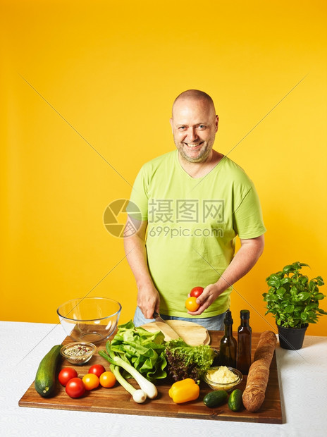 餐桌上新鲜沙拉成分中年人复制空间和黄色背景桌子男切碎图片