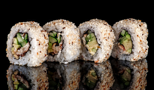 生的广告以黑背景为主的几张寿司卷本配有鱼蔬菜和不成熟酱的寿司卷本反射少数寿司卷本紫菜图片