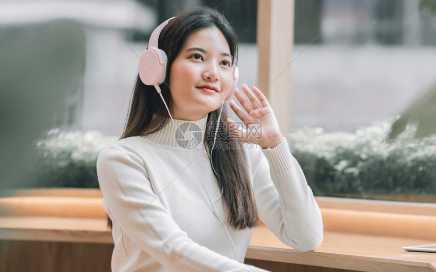 女联系美丽的冬季戴耳机听音乐的亚洲美女生活方式与休闲理念图片