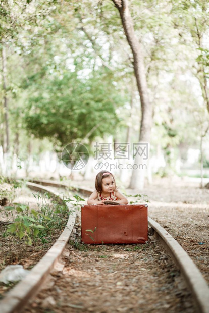 愉快旅行童年穿着旧衣服的可爱白种女孩在废弃铁路上装着旧式手提箱图片