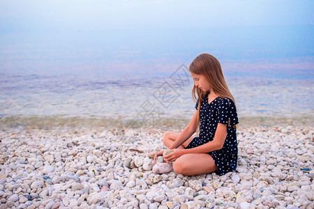 海滨可爱的小女孩在沙滩上玩得开心图片